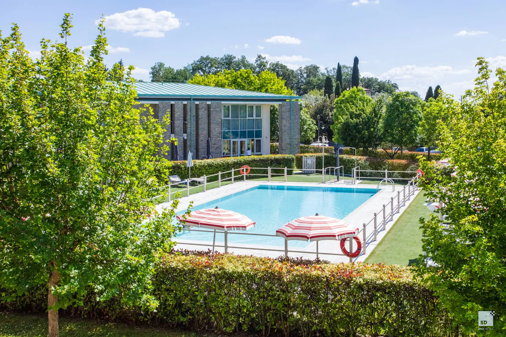 Piscina con ombrelloni a righe bianche e rosse